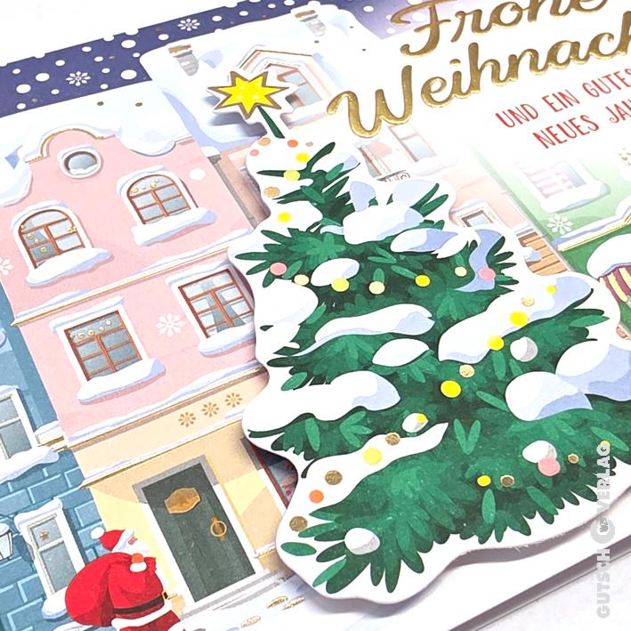 Eine Weihnachtskarte mit einem schneebedeckten Baum, einem kleinen Weihnachtsmann und einer winterlichen Dorfszene mit goldener Beschriftung.