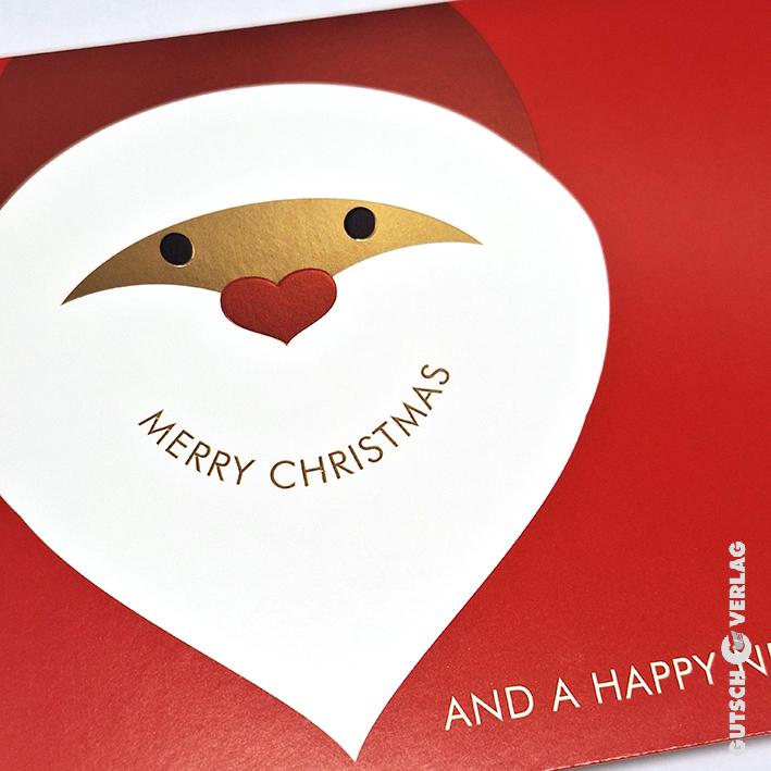 Eine festliche Weihnachtskarte mit einem lächelnden Weihnachtsmanngesicht mit Herz und dem Text „Frohe Weihnachten“.