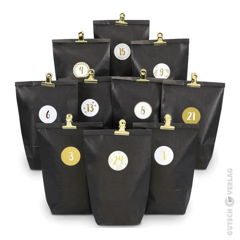 Schwarzer Adventskalender aus Packpapier mit goldenen Klammern.