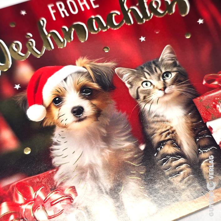 Ein süßer Welpe mit Weihnachtsmütze und ein getigertes Kätzchen sitzen zusammen vor einem festlichen roten Hintergrund mit goldenem Text.