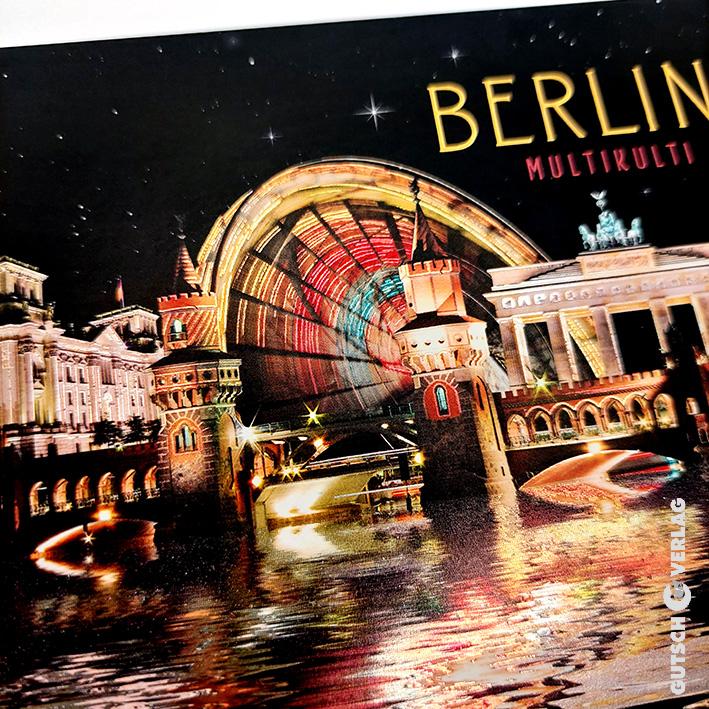 Nachtansicht der Wahrzeichen Berlins, beleuchtet durch bunte Lichter, die sich im Wasser spiegeln.