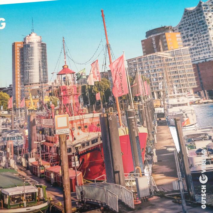 Bunte Boote legten an einem lebhaften Hafen an, mit modernen Gebäuden im Hintergrund unter einem klaren blauen Himmel.